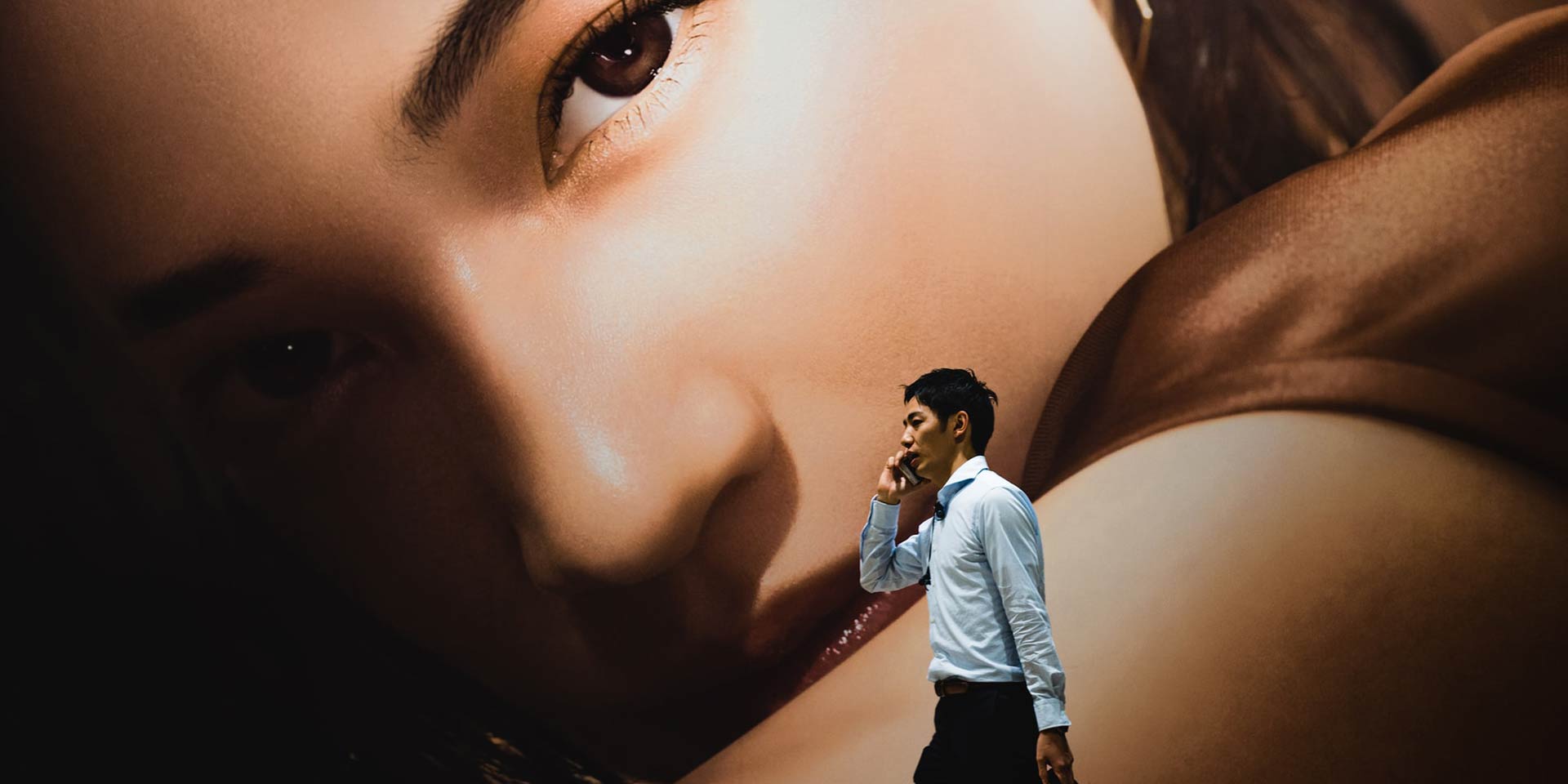 Man walking in front of a business advertisement